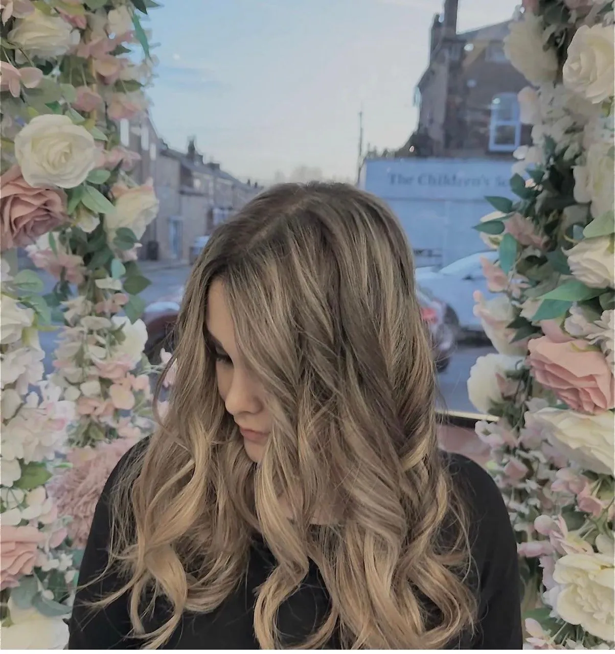 Sun-kissed balayage waves photographed through the flower arch